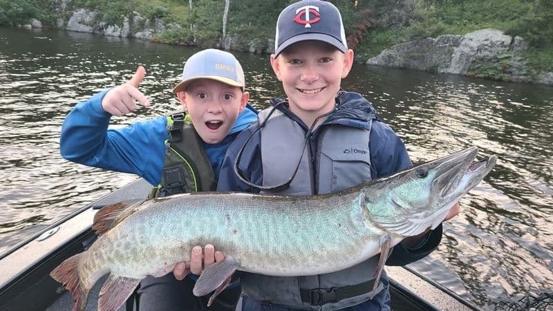 Kids handle a musky fish