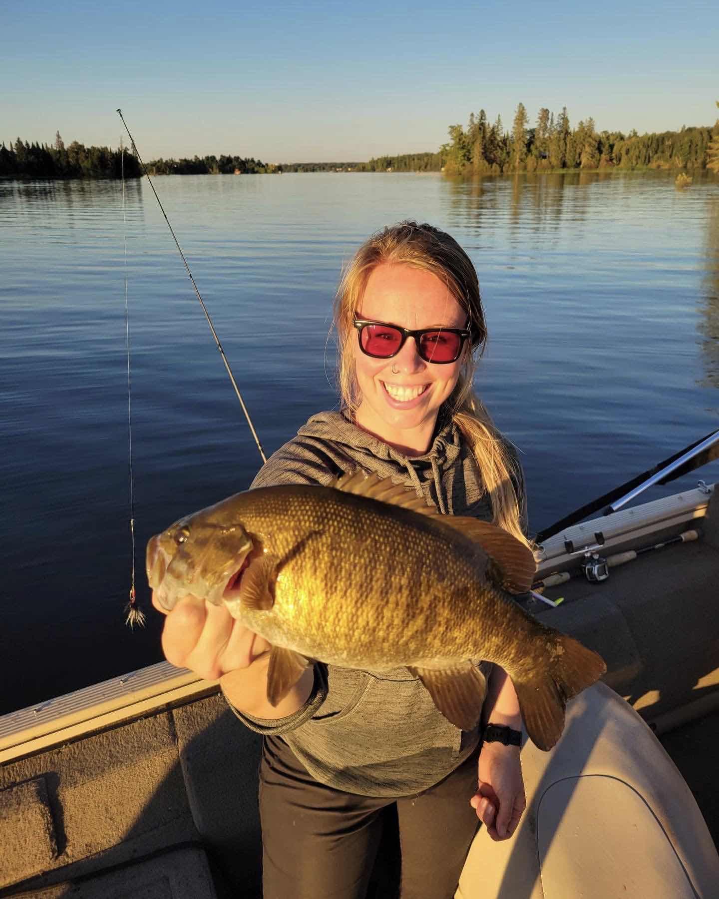 Woman handles a smallmouth bass fish